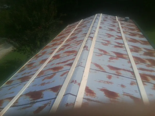 Rusted metal roof panels with new wood purlins before replacement — Storm Damage Roof Repair in Fayetteville by Roofing Brothers
