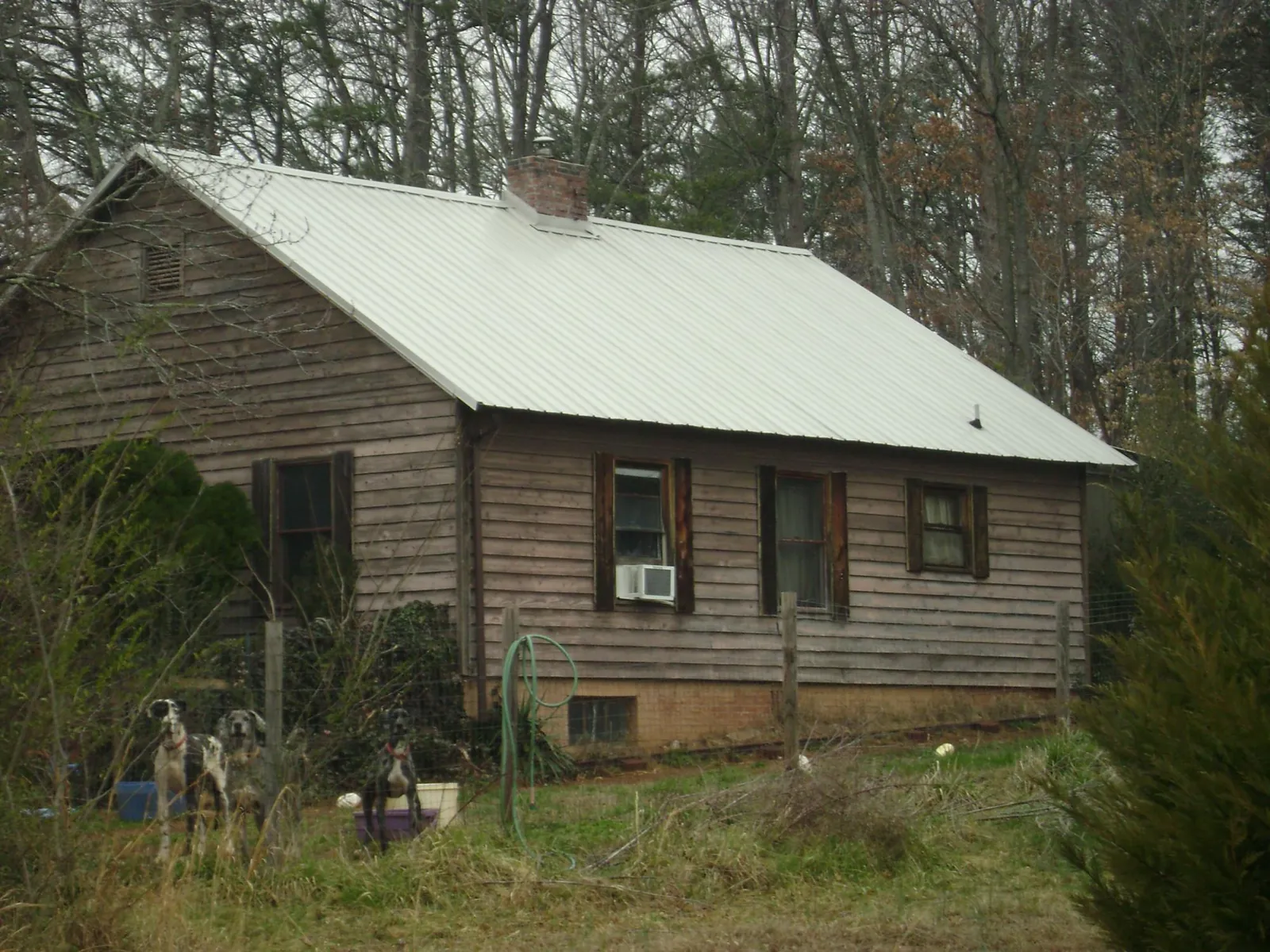White metal roof on an old wood sided farmhouse, from a Metal Roof Installation job in Fayetteville
